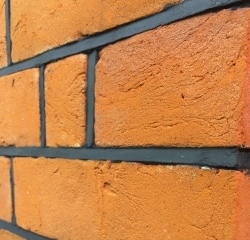 Neat and regular black mortar pointing with face of mortar inclined inwards towards upper edge